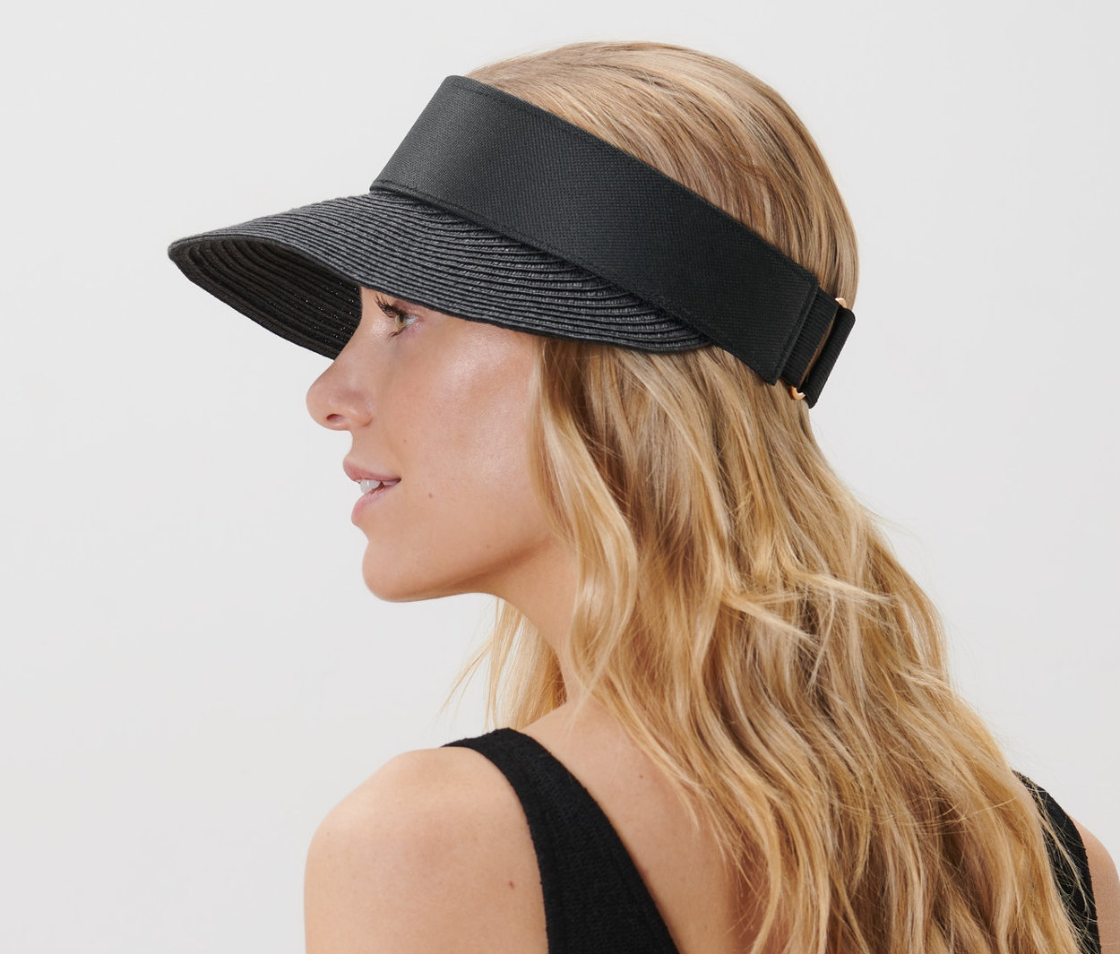 Femme blonde portant une visière noire.