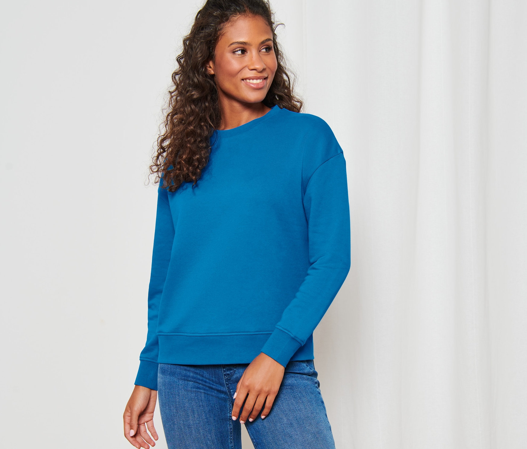 Femme posant dans un sweat-shirt bleu azur.