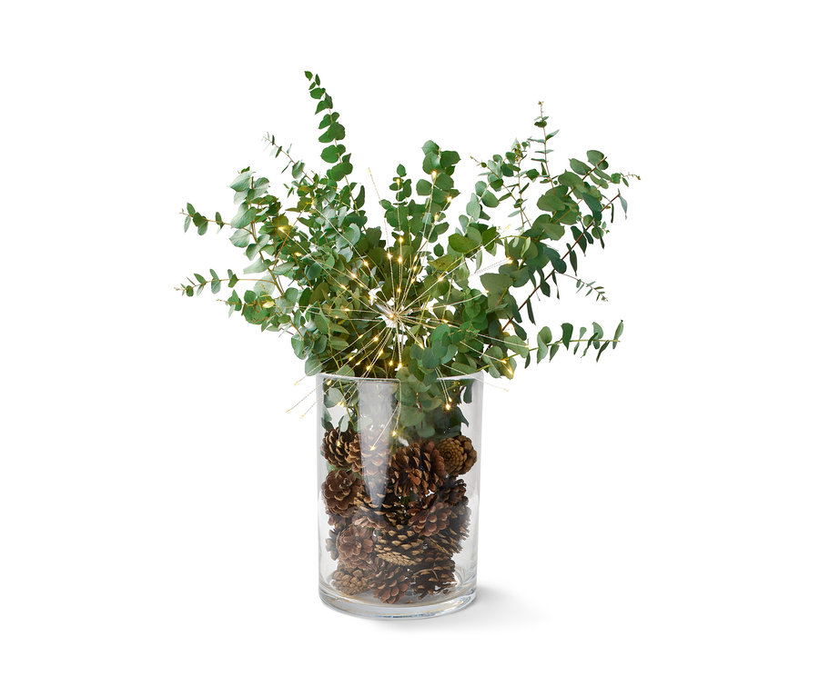 Décoration dans un vase en verre : pommes de pin, eucalyptus et branche décorative à LED.