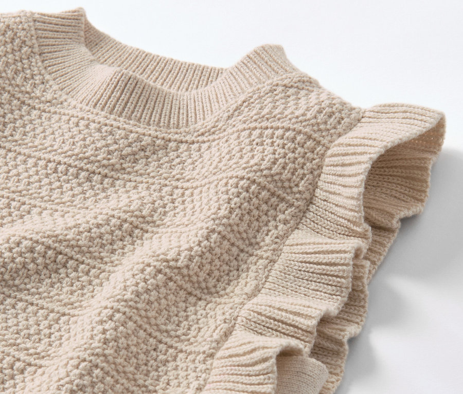 Vue détaillée d'un pull sans manches en maille pour enfant.
