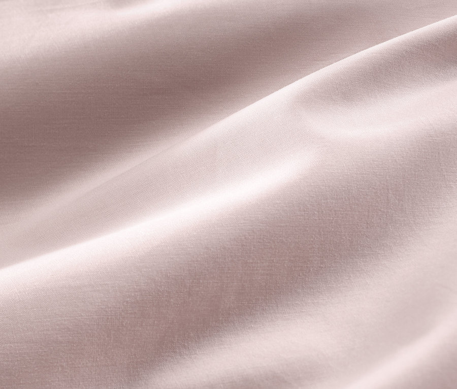 Gros plan d'une parure de lit rose en satin de coton de taille standard et grande taille.