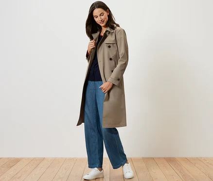 Femme portant un trench-coat beige.