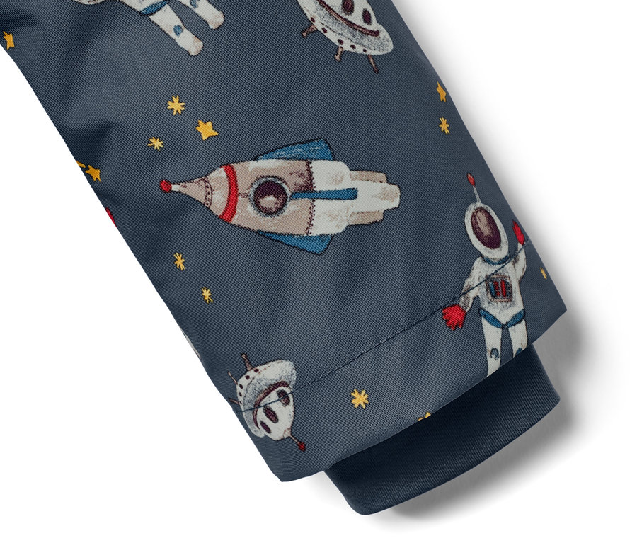 Détail d'une veste de pluie thermique pour enfant bleu foncé avec un motif spatial.