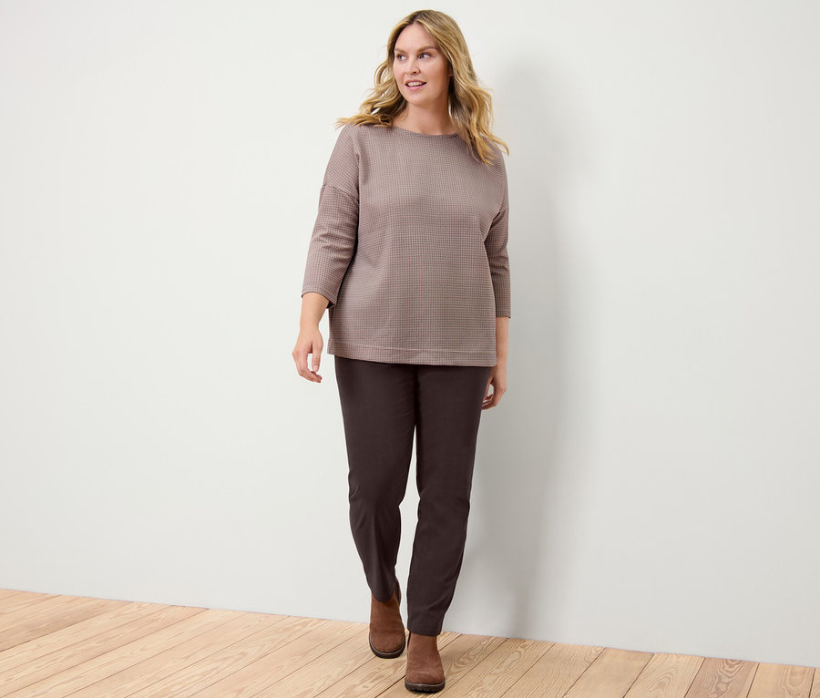 Femme portant un sweat-shirt à carreaux et un pantalon en bengaline.