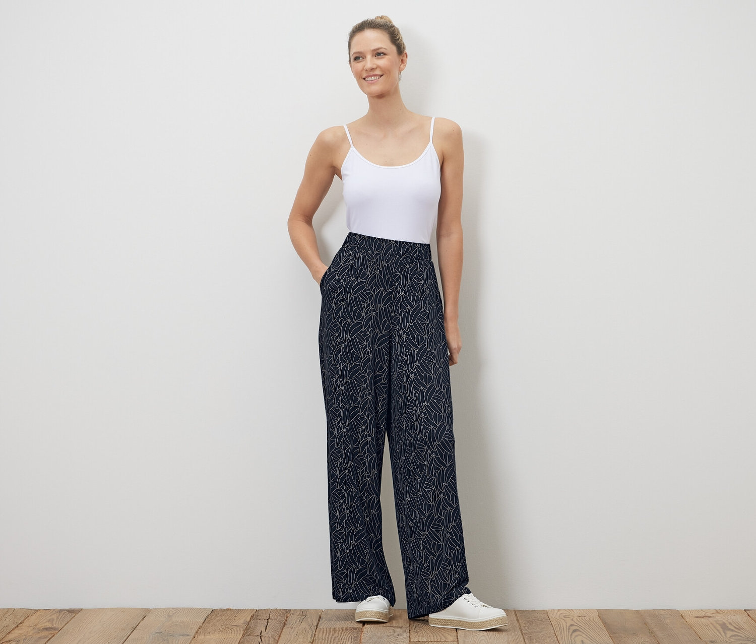 Femme posant en pantalon palazzo imprimé bleu foncé-blanc crème.