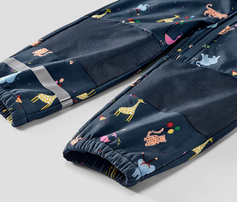 Détail d'une combinaison en softshell pour enfant avec des motifs d'animaux.