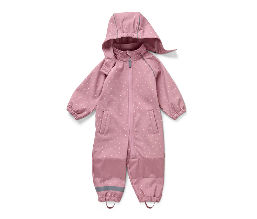 Combinaison en softshell rose pour enfant avec des pois blancs, posée sur un fond blanc.