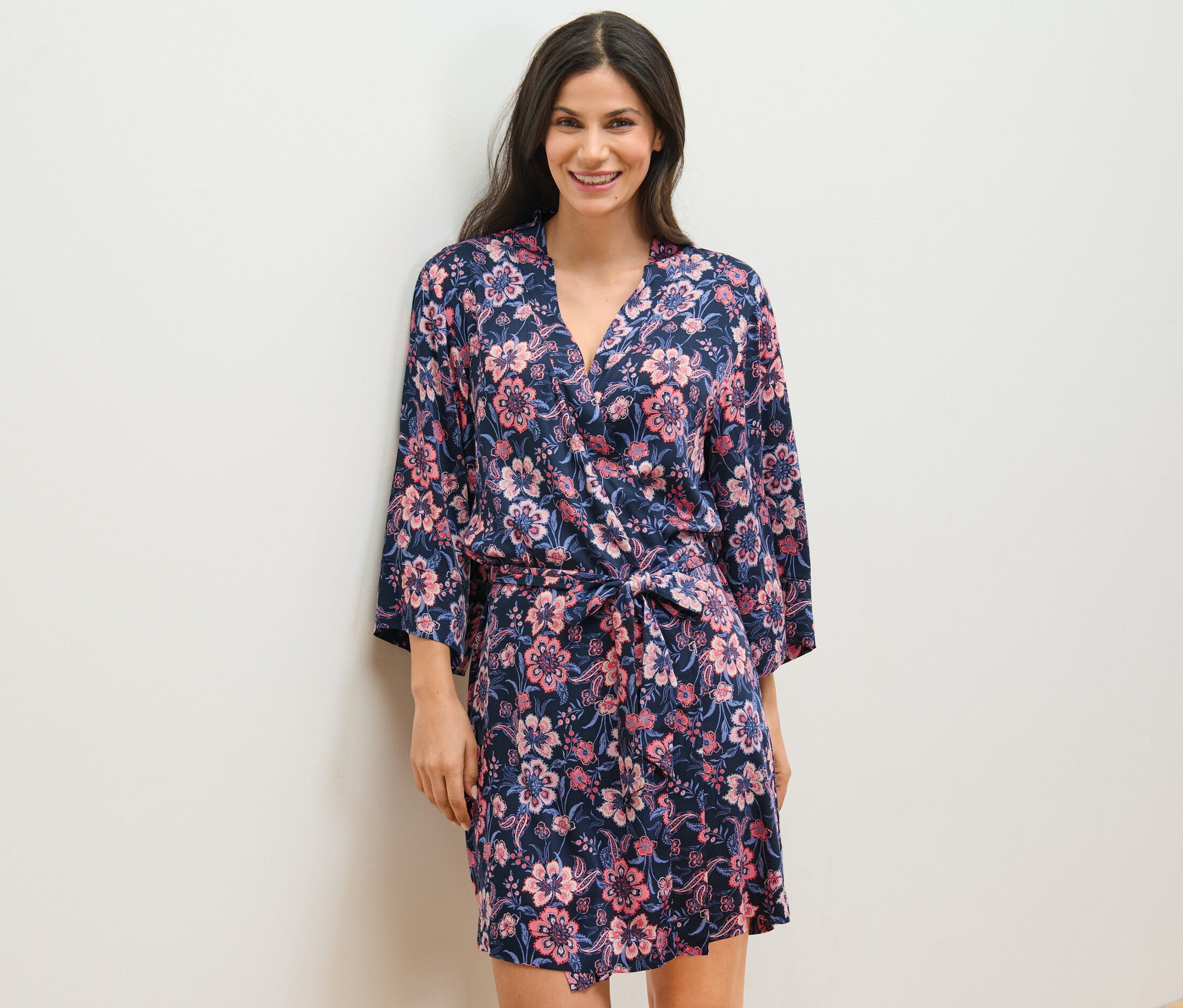 Une femme porte une robe de chambre tissée à motifs floraux.