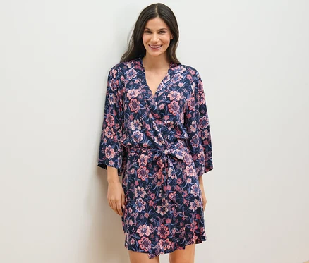 Une femme porte une robe de chambre tissée à motifs floraux.