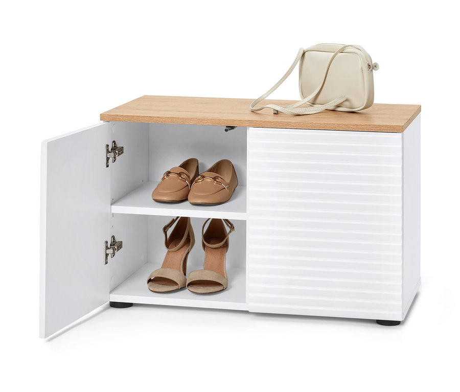 Un banc blanc ouvert avec espace de rangement, avec un sac à main beige dessus et des chaussures à l'intérieur.