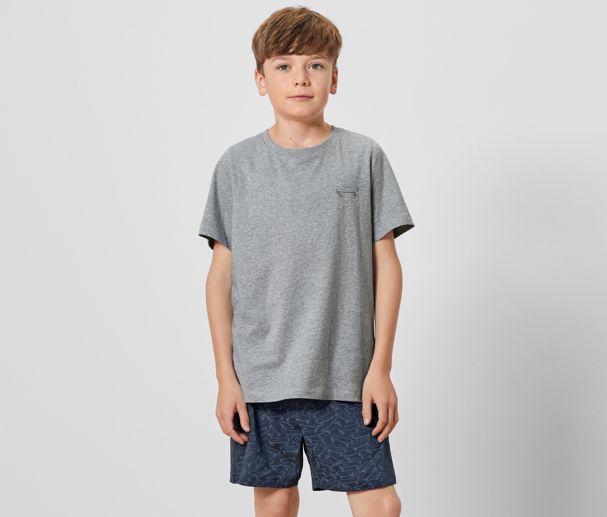Garçon portant un t-shirt gris et un pyjama court pour enfant.