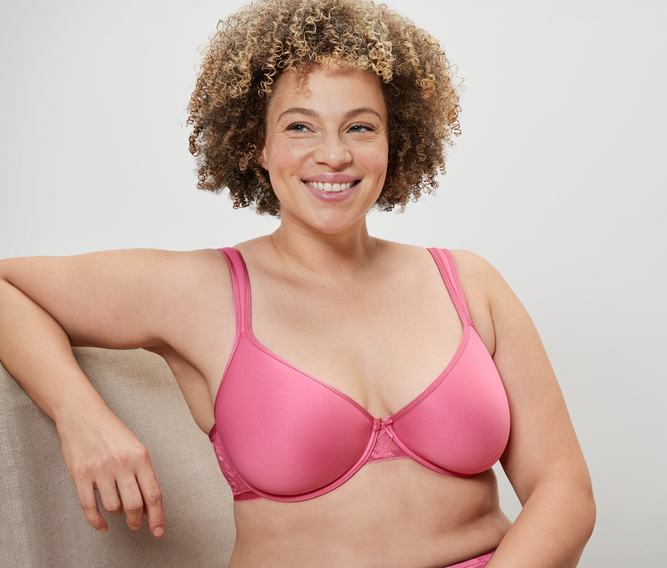 Femme aux cheveux bouclés portant un soutien-gorge Spacer rose.