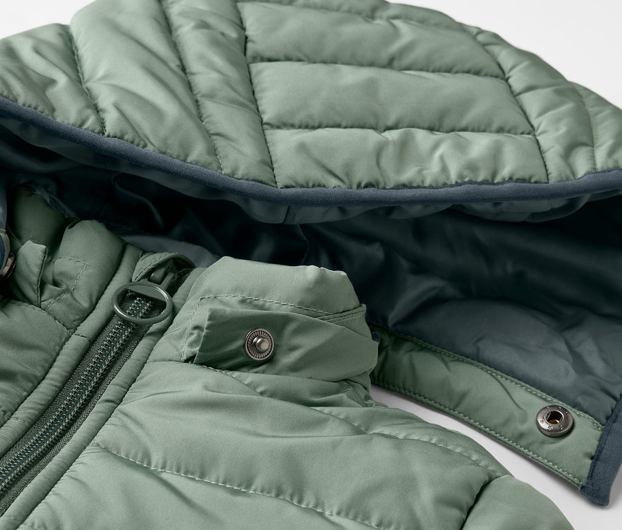 Gros plan sur un anorak matelassé vert pour enfants.