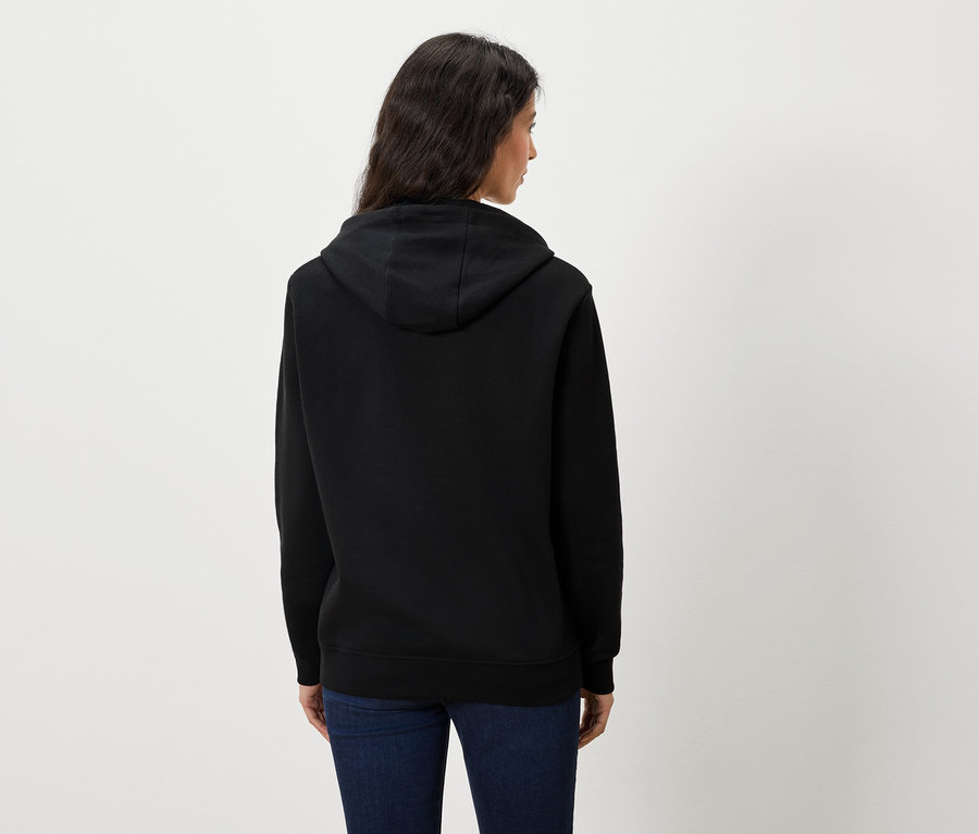 Vue arrière d'une femme portant un sweat à capuche noir et un jean bleu.