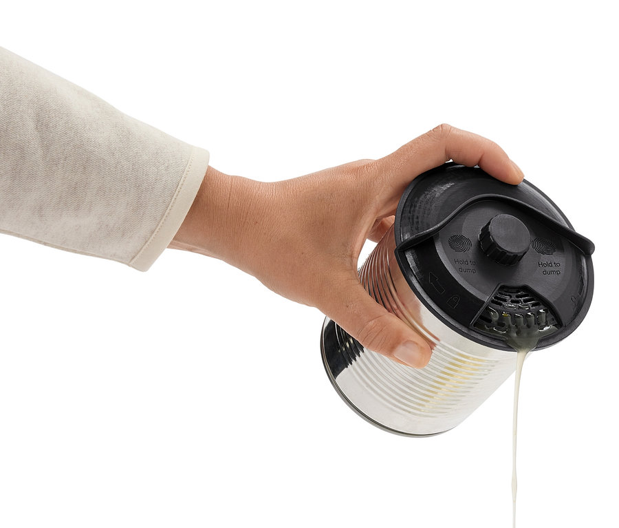 Une main incline une boîte de conserve avec un couvercle noir, versant du liquide.