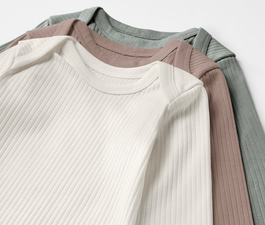 Trois bodys côtelés à manches longues pour bébé en blanc, marron et vert.