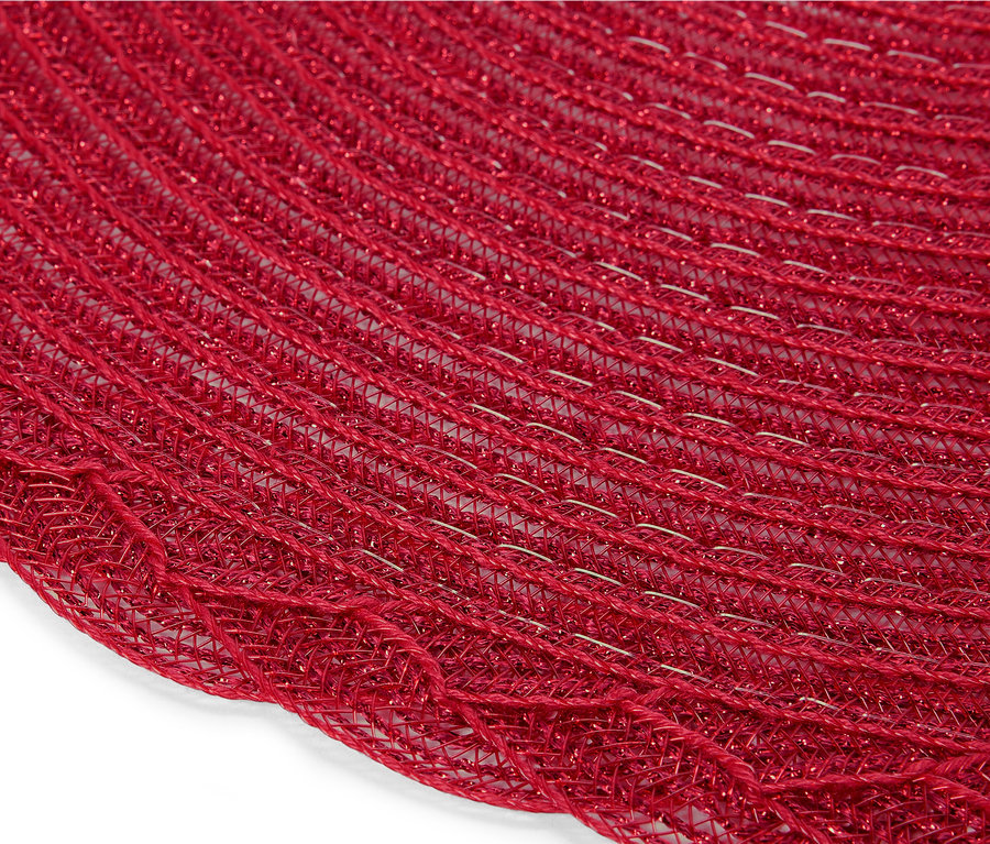 Gros plan d'un napperon rond rouge en maille tressée.