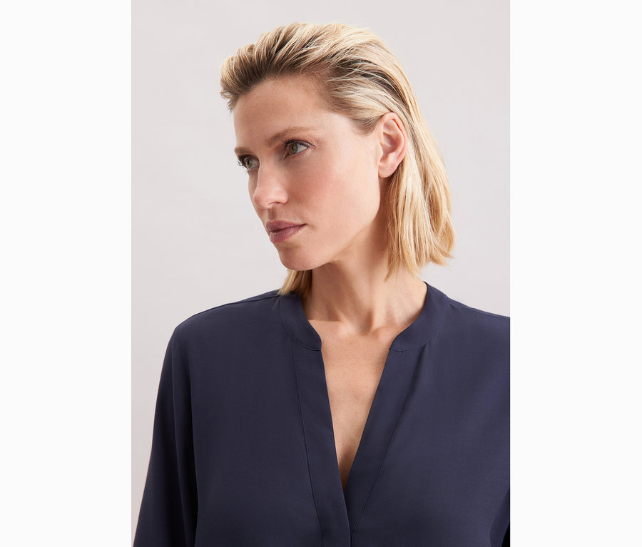 Femme portant une tunique en viscose bleu marine Seidensticker.