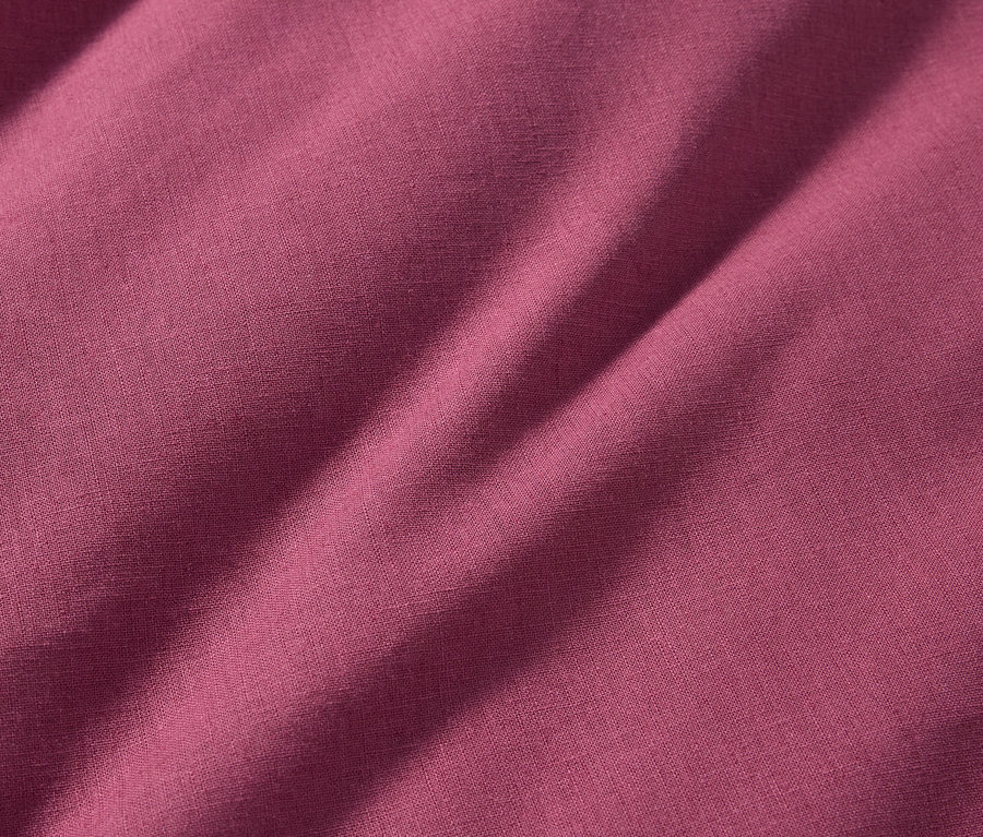 Gros plan sur une parure de lit en tissu métis de taille standard dans une teinte rose foncé.