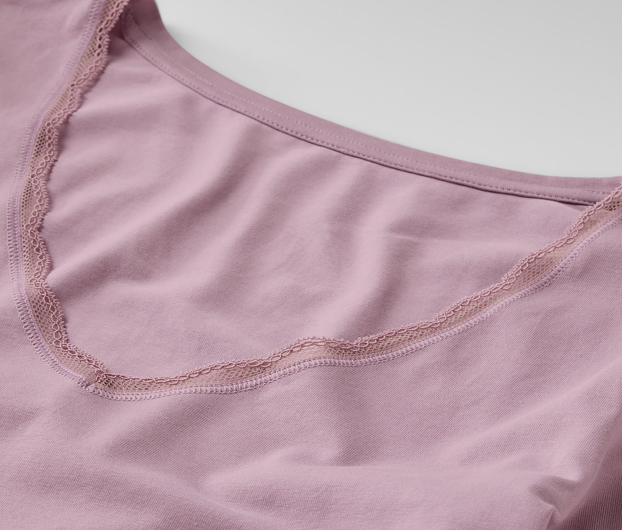 Gros plan sur un maillot de corps manches longues violet avec bordure en dentelle.