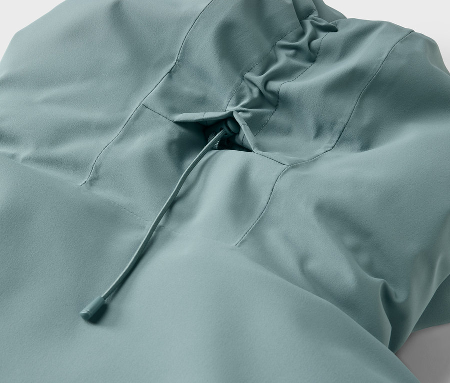 Détail d'une veste bleu clair avec capuche et cordon de serrage.