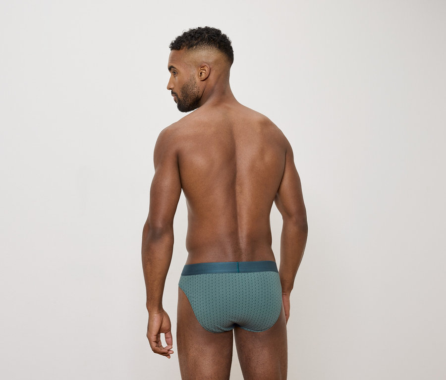 Un homme vu de dos portant un slip vert.