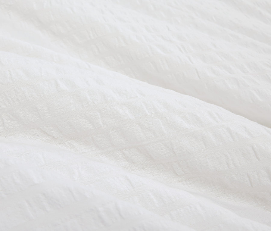 Gros plan d'un tissu blanc texturé.
