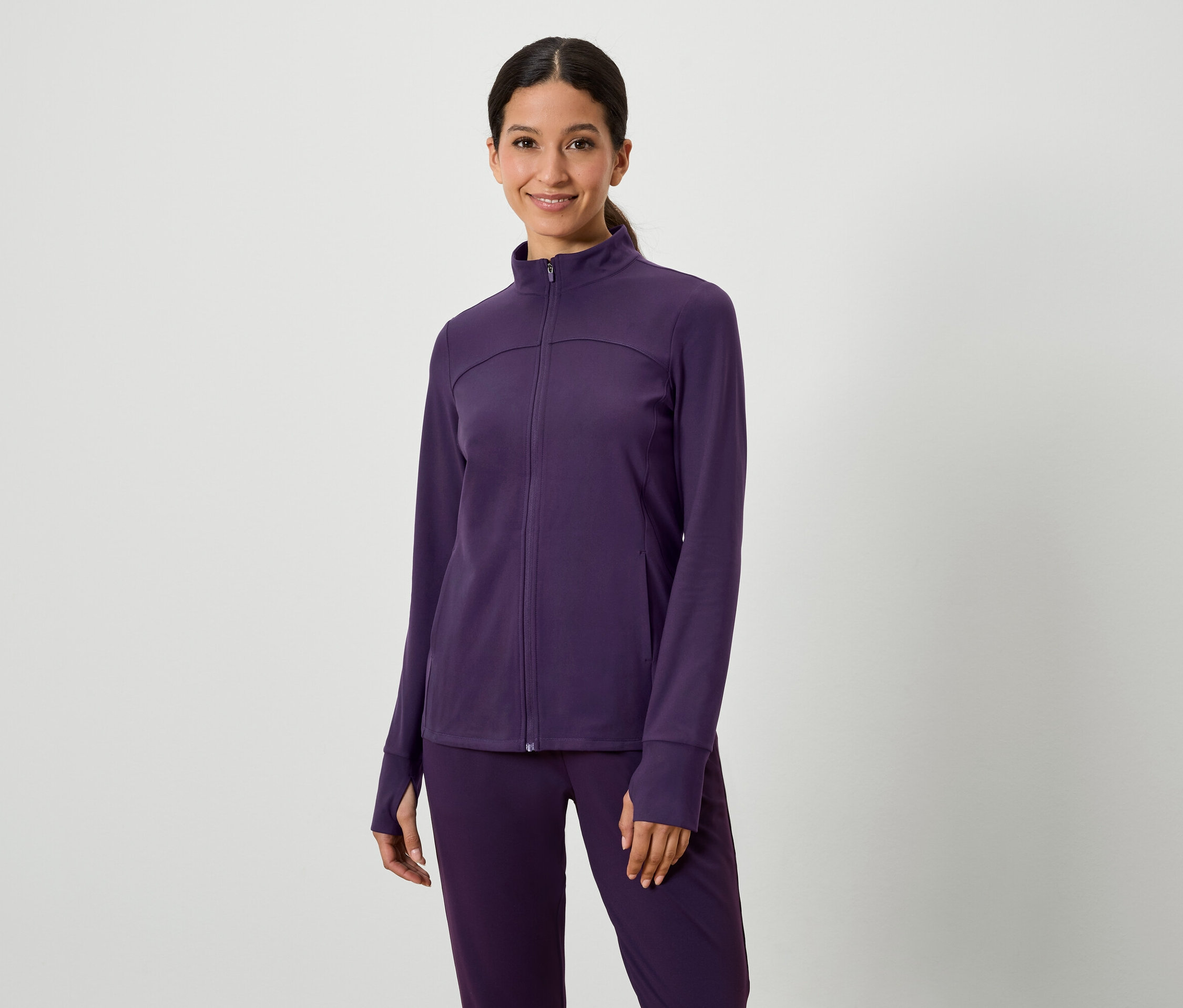 Femme posant dans un ensemble violet veste et pantalon.