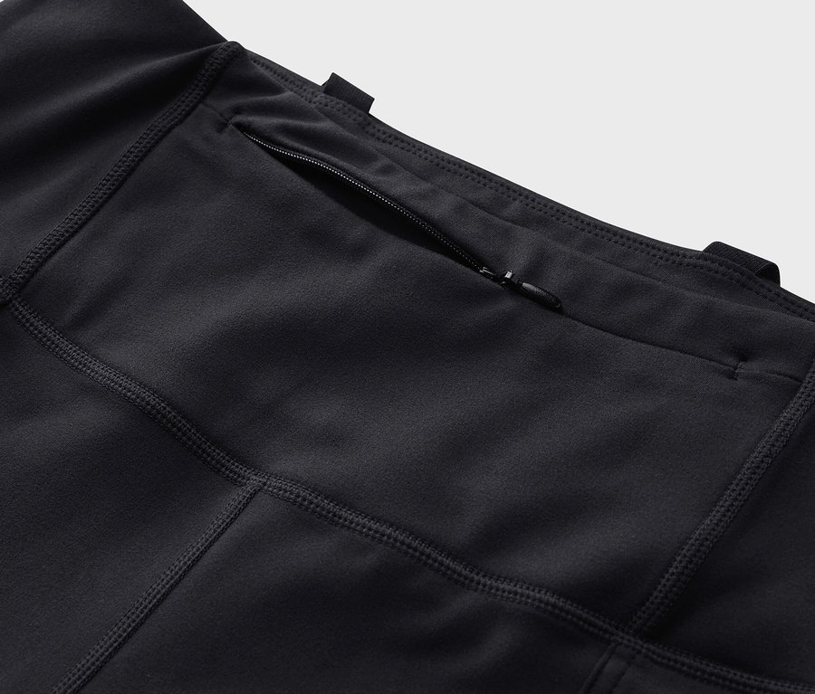 Gros plan sur un collant d’extérieur noir avec une poche zippée.