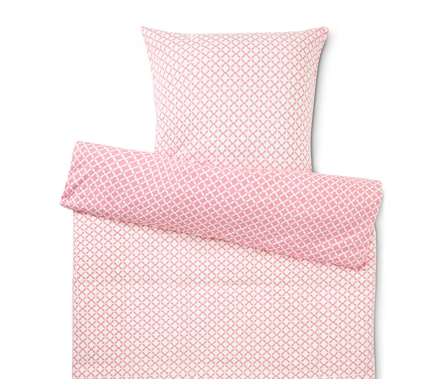 Gros plan d'une housse de couette et d'une taie d'oreiller avec un motif rose et blanc.