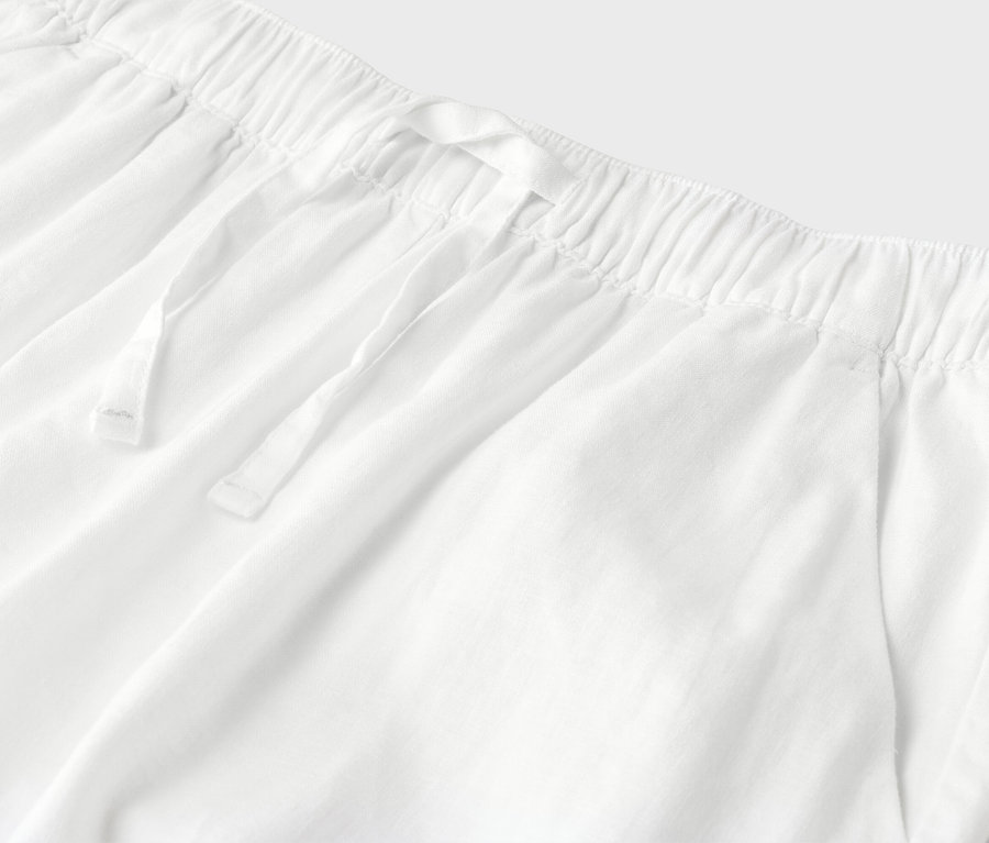 Gros plan d'un pantalon blanc avec cordon de serrage et taille élastique.