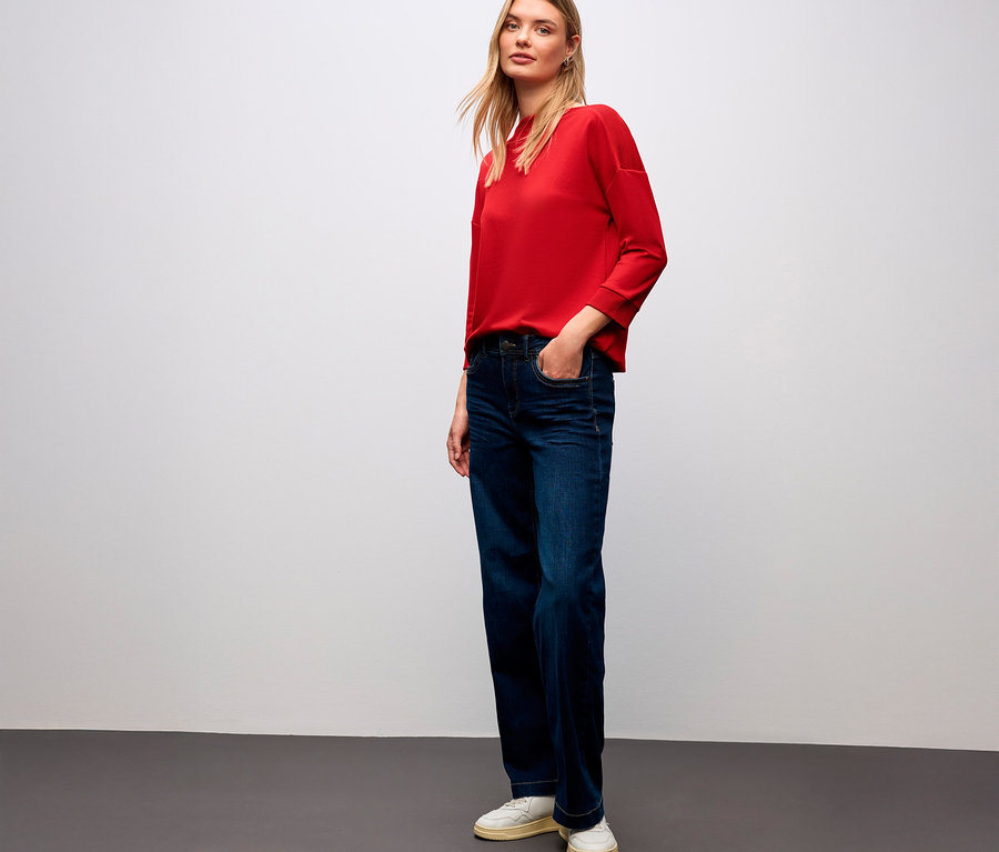 Femme portant un t-shirt rouge Street One avec détails côtelés et un jean.