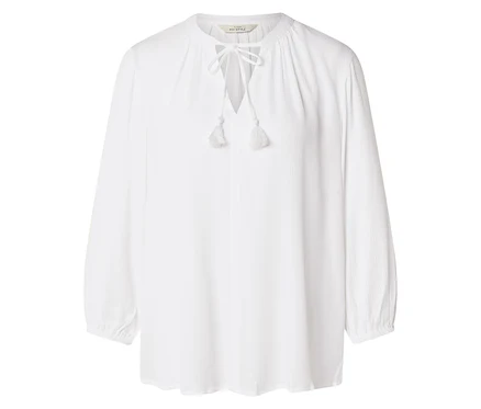 Une chemise blanche à manches longues avec des lacets et des pompons est visible sur un fond blanc.