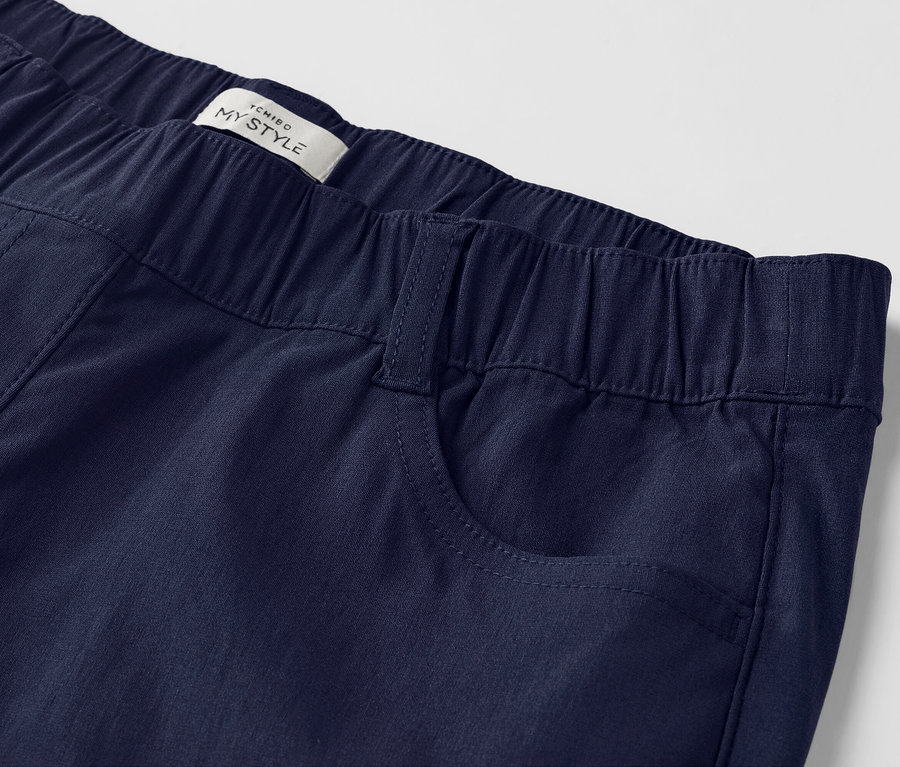 Gros plan sur un pantalon bleu marine avec une taille élastique et des poches plaquées.