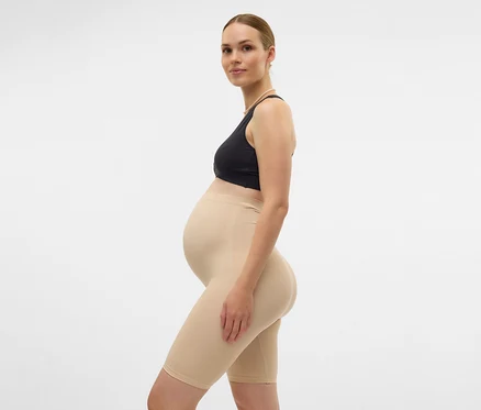 Femme enceinte en soutien-gorge de sport et Skinny Shorts MAMALICIOUS «
MLTIA JEANNE
», noir, de profil sur fond blanc.