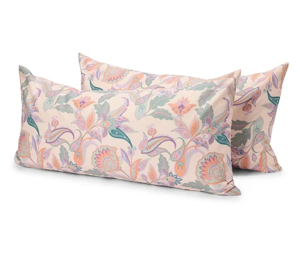 Trois coussins rectangulaires avec un motif floral clair sont posés les uns sur les autres.