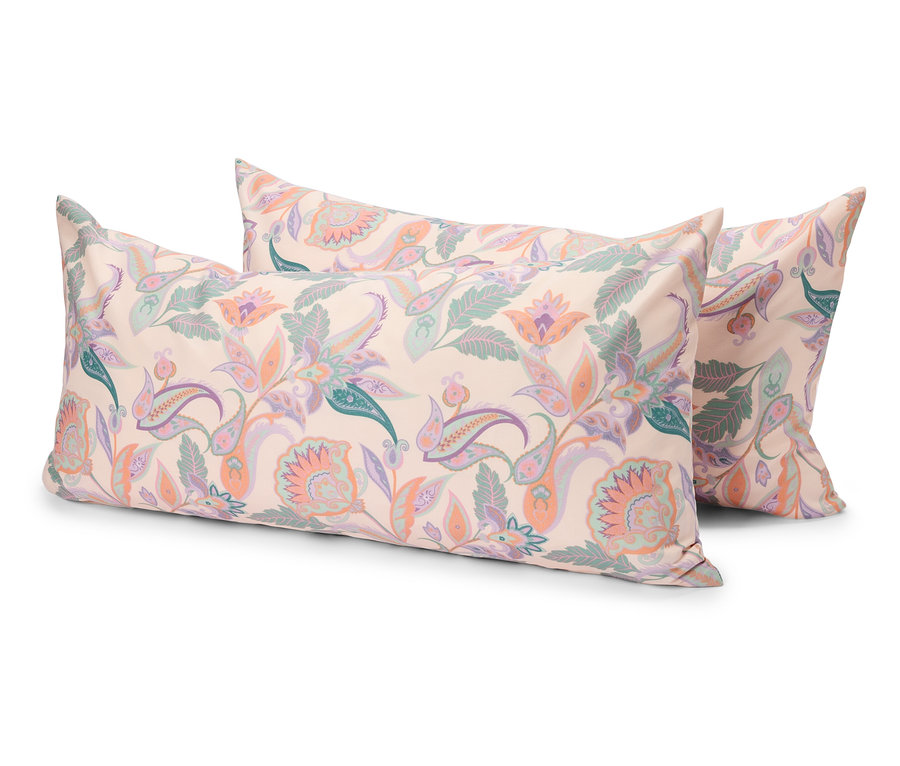 Trois coussins rectangulaires avec un motif floral clair sont posés les uns sur les autres.