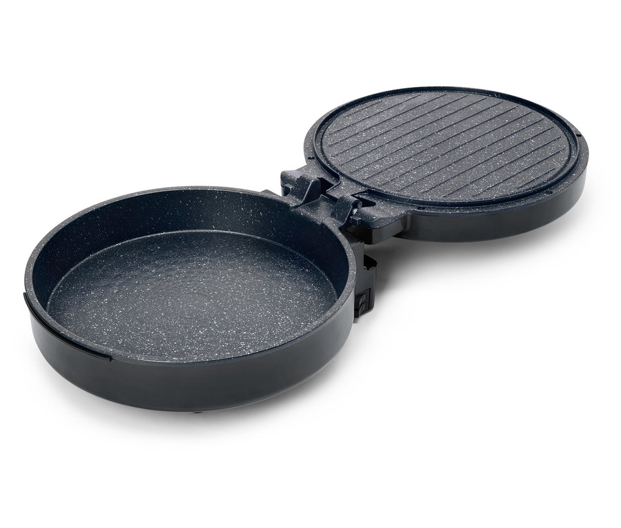 Poêle à griller noire, ronde et ouverte, avec un dessus rainuré et un intérieur moucheté.