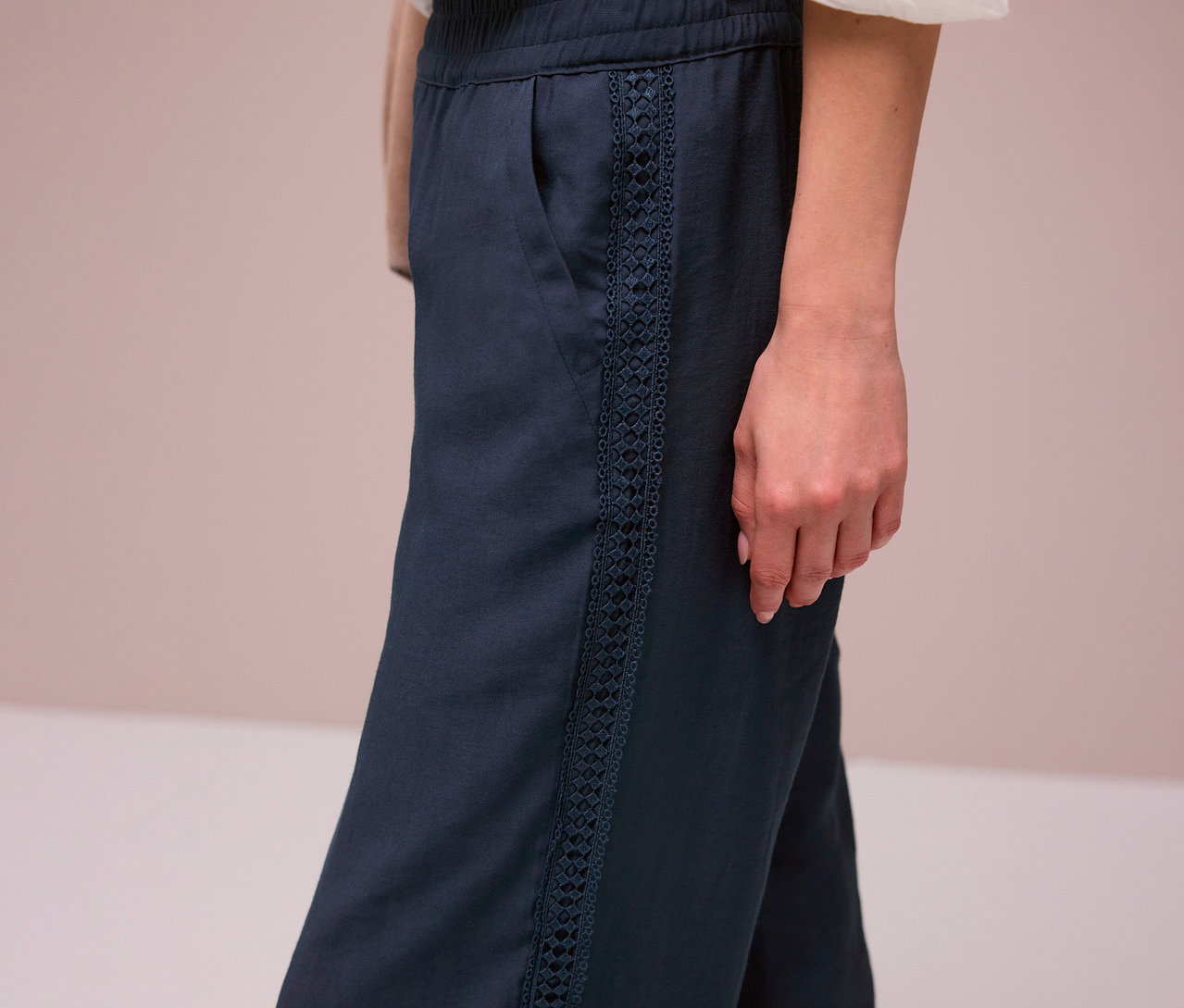 Une femme porte le pantalon bleu marine Street One « Emee » avec des rayures décoratives.