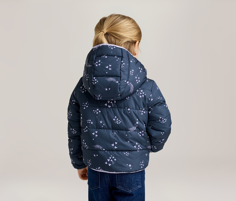 Vue arrière d'un enfant blond portant un manteau bouffant bleu marine à capuche avec un motif d'étoiles filantes et un jean.