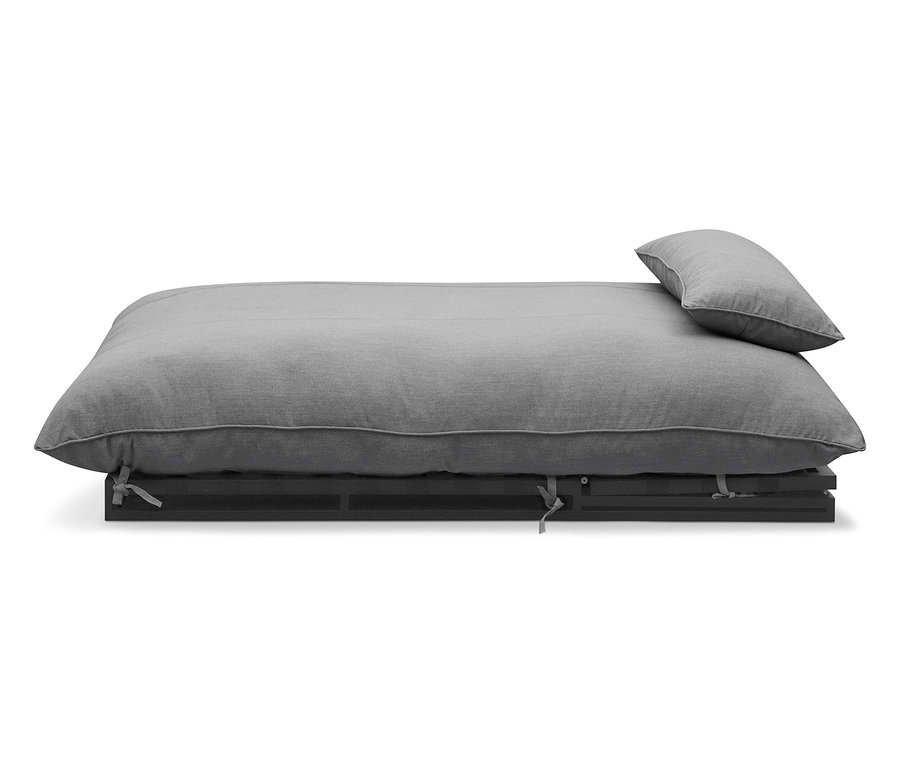 Lit futon gris avec oreiller sur cadre en bois foncé.
