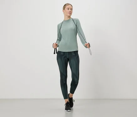 Femme en tenue de sport tenant une corde à sauter.