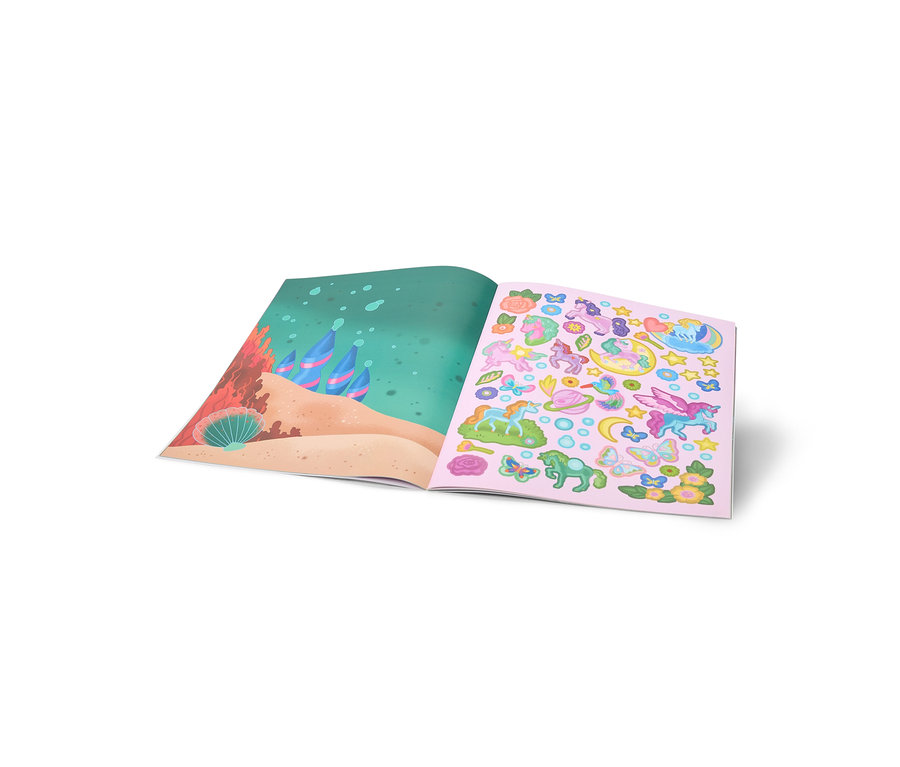 Un livre d'autocollants ouvert montre une scène sous-marine avec du sable et des coraux sur la page de gauche, et des autocollants colorés de licornes, papillons et fleurs sur fond rose sur la page de droite.