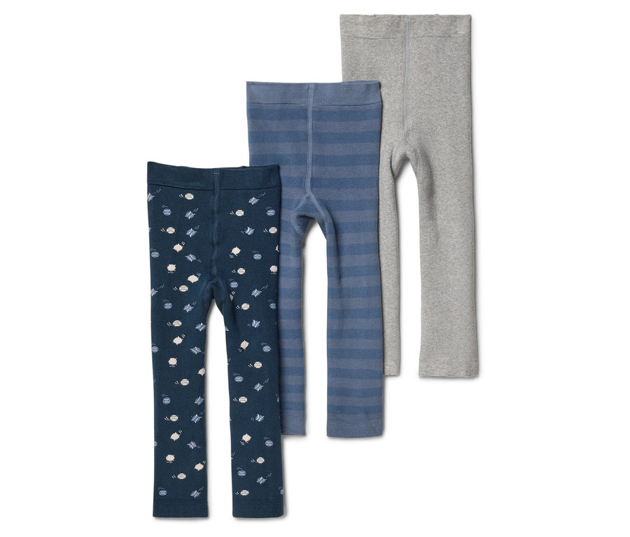 Trois leggings pour enfants sont posés côte à côte: un bleu foncé à petits motifs, un bleu à rayures horizontales et un gris clair uni.