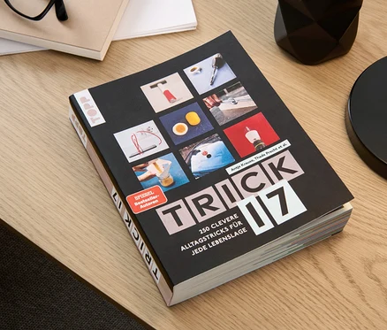 Le livre « Trick 17 » est posé sur une table à côté de lunettes, d'un bloc-notes et d'un pot à crayons.