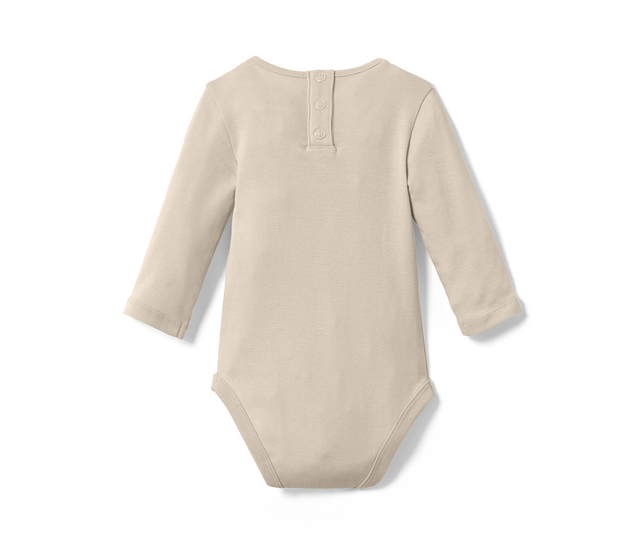 Un body beige à manches longues est posé sur un fond blanc. Trois boutons sont visibles dans le dos.