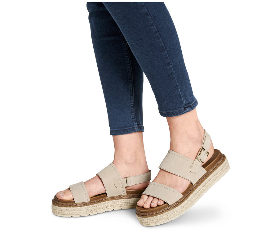 Pieds en jean portant des sandales à plateforme en cuir.