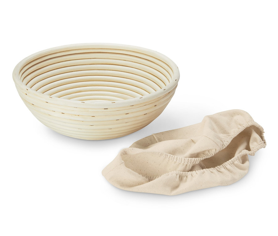 Un banneton rond vide et une housse en tissu beige.