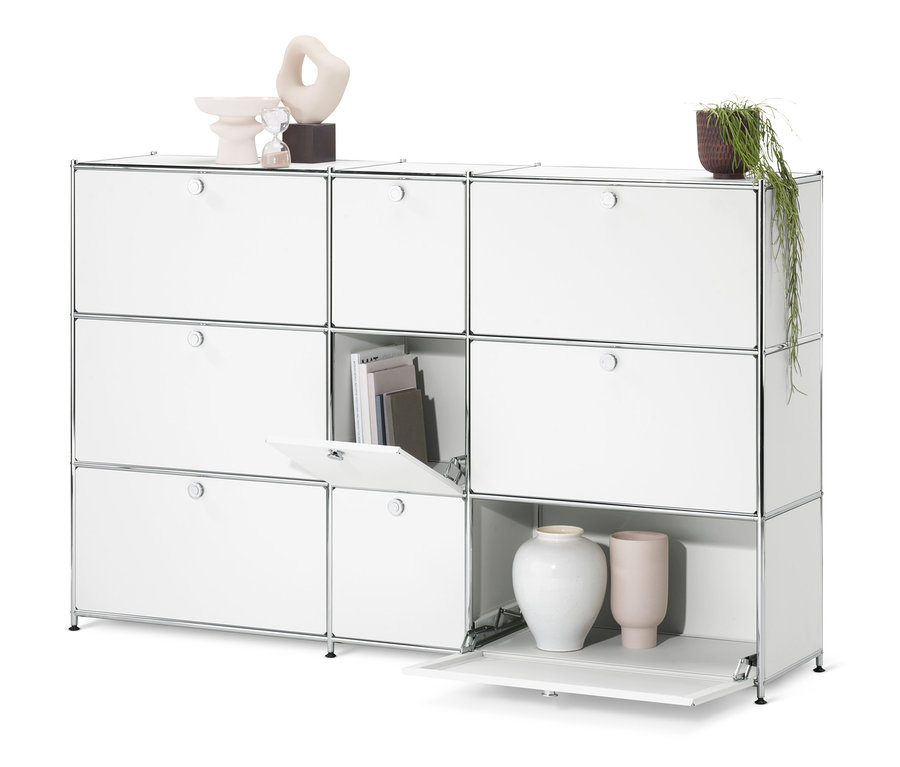 Commode « CN3 » blanche avec 9 abattants dont un ouvert, avec des livres et de la décoration.