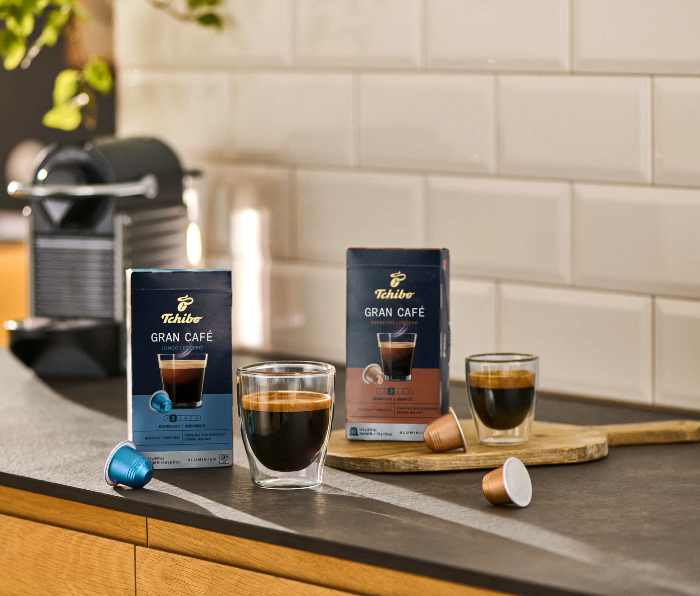 Sur un comptoir de cuisine, des paquets de Gran Café Lungo Leggero et de Gran Café Espresso Leggero sont placés à côté de tasses à café.